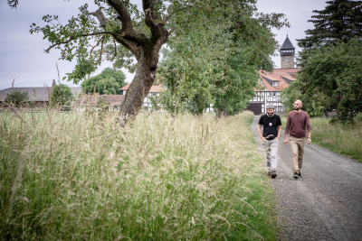 Die Brüder Carsten und Samuel Waldeck laufen einen Feldweg entlang.
