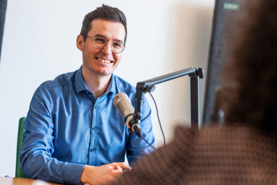 Johannes Salzer sitzt vor einem Mikrofon.